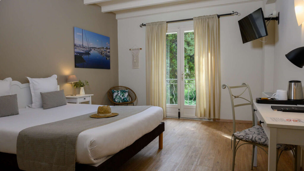 Grand Plan sur une chambre avec lit double et un bureau avec tv - hotel restaurant les baux de provence - Belesso 